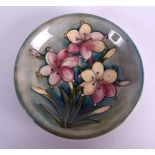 A WILLIAM MOORCROFT CIRCULAR DISH decorated with three floral sprays. 18 cm diameter.