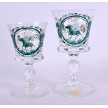 A 19TH CENTURY GERMAN EAMELLED GLASS CUP together with a matching cup, painted with stags within