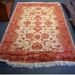 A 20TH CENTURY RED GROUND ZIEGLER RUG, decorated with foliage. 190 cm x 140 cm.