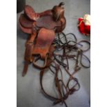A GOOD 19TH/20TH CENTURY LEATHER SADDLE, decorated with extensive foliage, together with