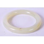 A CHINESE CARVED WHITE JADE BANGLE, of plain form. 8 cm wide (5.5 cm inner diameter)