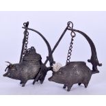 A PAIR OF EARLY 20TH CENTURY BRONZE OIL LAMPS, in the form of standing pigs.9 cm wide.