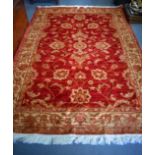 A 20TH CENTURY ZIEGLER RED GROUND RUG, decorated with foliage. 230 cm x 160 cm.