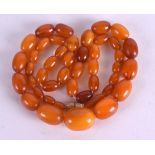 AN EARLY 20TH CENTURY ORANGE AMBER NECKLACE. 23 grams. 52 cm long.