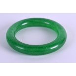 A CHINESE CARVED GREEN JADE CIRCULAR BANGLE 20th Century. 7.75 cm diameter.