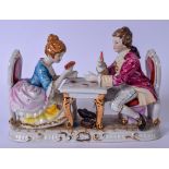 A CAPODIMONTE PORCELAIN FIGURAL GROUP OF A MALE AND FEMALE PLAYING CARDS , formed seated at a