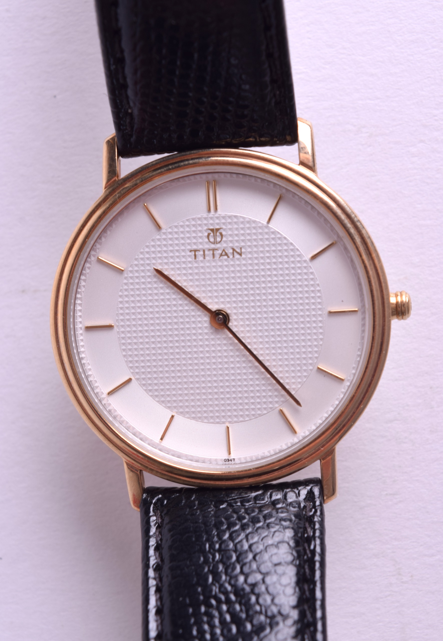 A 9CT TITAN GENTLEMANS WRISTWATCH with white face and gilt numerals. 3 cm diameter.