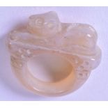 A HARDSTONE RING, carved with a mythical beast. 3.3 cm wide.