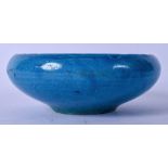 A 19TH CENTURY ISLAMIC TURQUOISE GLAZED POTTER BOWL, of flattened form. 16 cm wide.