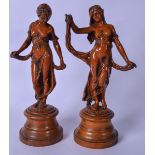 A PAIR OF EARLY 20TH CENTURY BRONZE FIGURES OF FEMALES, modelled standing on turned wooden bases.