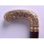 A MID 19TH CENTURY FRENCH HIGH CARAT GOLD HANDLED WALKING CANE decorated in repousse work with