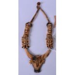 AN EARLY 20TH CENTURY BURMESE BONE NAGA NECKLACE, carved with the head of an ox and figures. Ox 8 cm