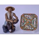 A CHINESE PORCELAIN FIGURE OF A SEATED TRADESMAN, together with a famille rose porcelain dish.