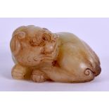 AN EARLY 20TH CENTURY CHINESE CARVED YELLOWISH JADE FIGURE OF A BEAST modelled recumbent with its