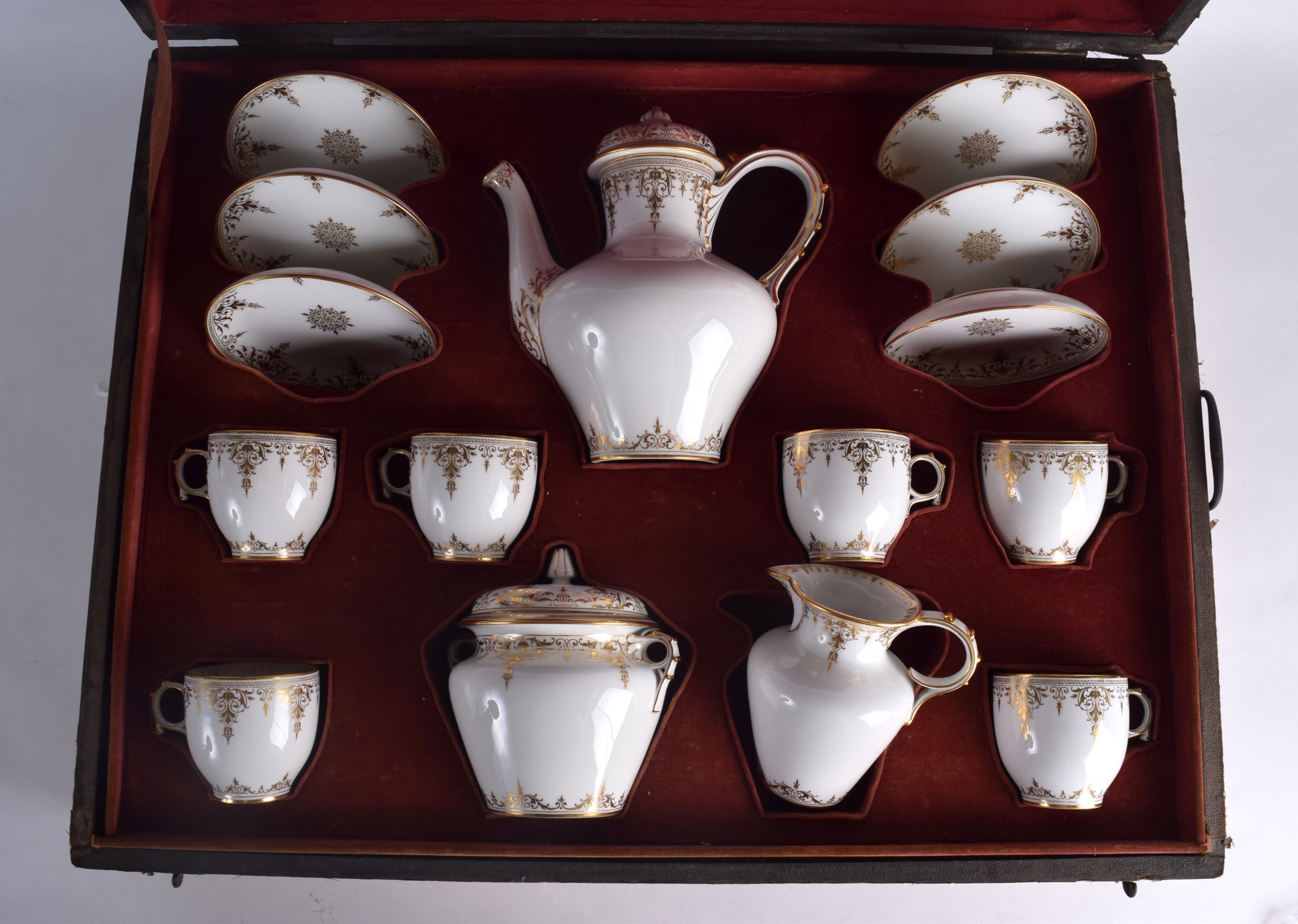 A GOOD CASED 19TH CENTURY FRENCH SEVRES PORCELAIN TEASET painted with rich gilt scrolling foliage.