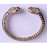 A LATE 19TH CENTURY CHINESE WHITE METAL BANGLE with dragon mask heads. 47 grams. 6.5 cm wide.