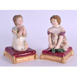 A RARE PAIR OF 19TH CENTURY DERBY FIGURES OF SEATED GIRLS modelled praying. 9 cm high.