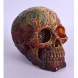 A LARGE CARVED AMBER SKULL decorated with scripture and motifs. 15 cm x 12 cm.