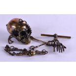 A NOVELTY BRASS SKULL SNUFF BOX with chain.