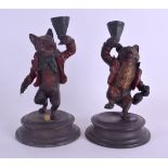 A PAIR OF COLD PAINTED BRONZE CANDLESTICKS in the form of standing foxes. 18 cm high.