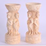 A PAIR OF CARVED BONE PUZZLE BALL STANDS in the form of figures. 9 cm high.