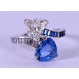 A STUNNING BOODLES 2 STONE PASSEND DESIGN RING comprised of a heart shaped diamond and sapphire,