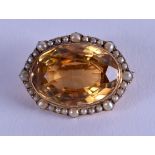 AN EDWARDIAN GOLD PEARL AND TOPAZ BROOCH. 3 cm wide.