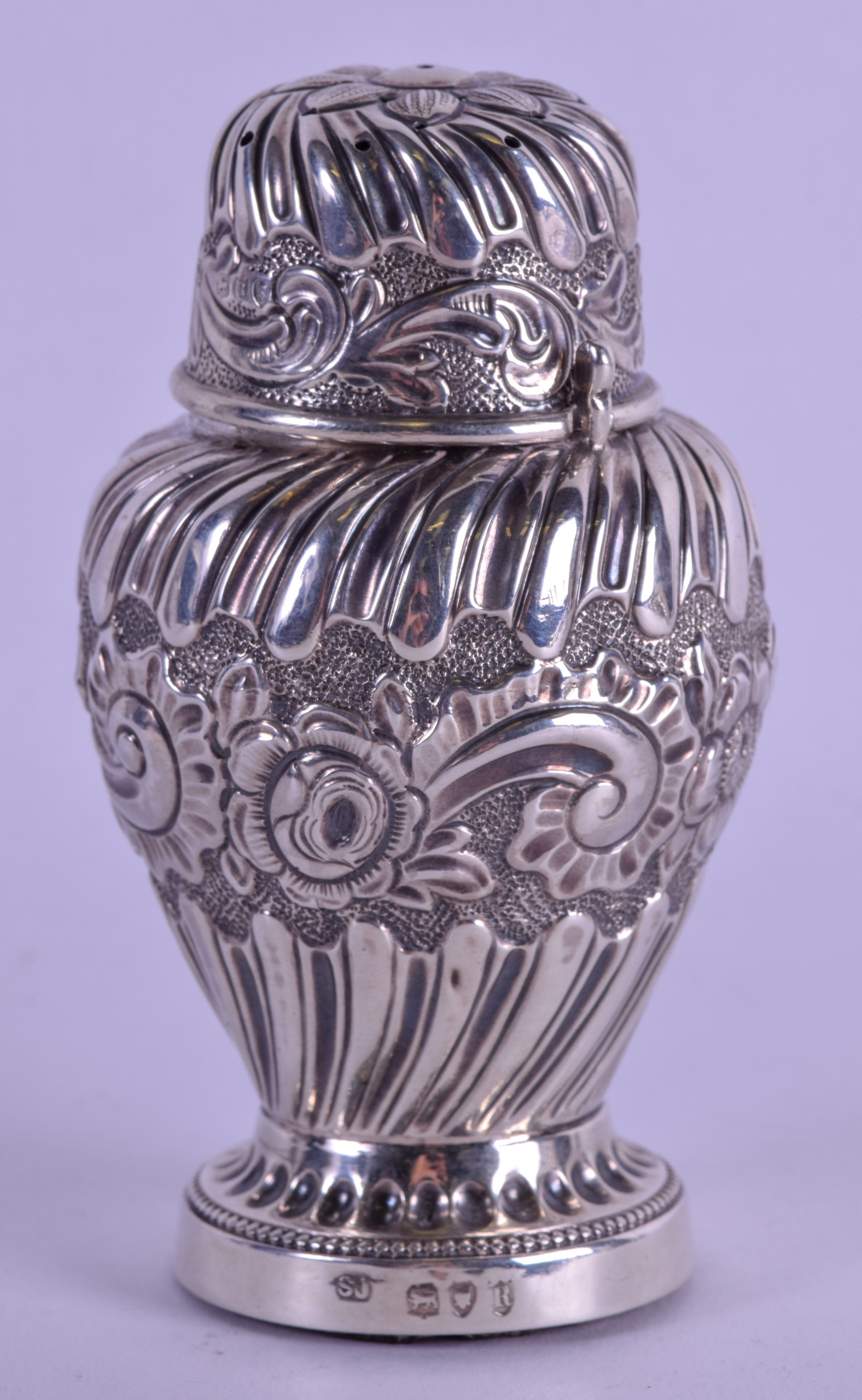 A LATE VICTORIAN EMBOSSED SILVER PEPPER POT. London 1892. 4 oz. 12 cm high.