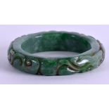 A CARVED GREEN JADE BANGLE. 8 cm wide.