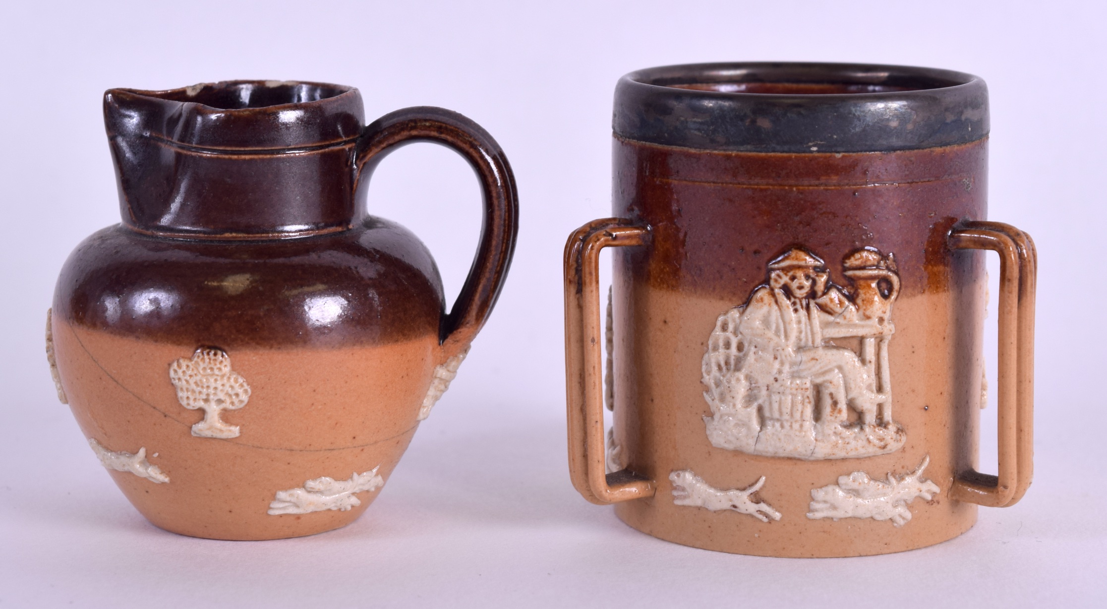 A MINIATURE DOULTON LAMBETH STONEWARE TYG together with another miniature Doulton jug. 4.25 cm high.