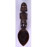 AN EARLY 20TH CENTURY AFRICAN TRIBAL CARVED SPOON modelled holding her stomach with bone eyes. 24 cm