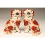 A PAIR OF VICTORIAN STAFFORDSHIRE PORCELLANEOUS SPANIELS, modelled seated with free standing fore-