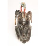 AN AFRICAN MASK from the Ivory Coast, late 19th/early 20th century, carved with horns and pecking