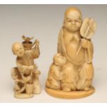 A JAPANESE IVORY SMALL FIGURE GROUP, carved as a seated bearded man wearing an open robe and