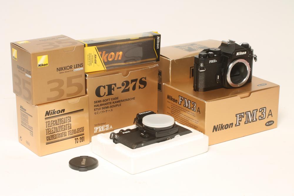 A BOXED NIKON FM2 AND BOXED NIKON FM3A, together with a boxed Nikkor 35mm lens, a boxed Nikon