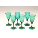 A SET OF SIX BRISTOL GREEN WINE GLASSES, the plain "U" shaped bowls issuing from knopped cylindrical