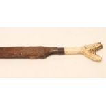 A DAYAK HEAD HUNTER'S SWORD, late 19th century, with 14 1/2" shaped and brass inlaid blade, carved