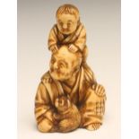 A JAPANESE SMALL ONE PIECE IVORY FIGURE GROUP, carved as a seated old man with a young boy on his