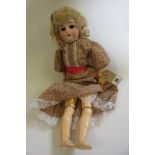 A Kammer & Reinhardt bisque head doll with dark brown glass sleeping eyes, open mouth and teeth,