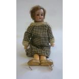 A Kammer & Reinhardt bisque head doll with blue glass sleeping eyes, open mouth and teeth, brown