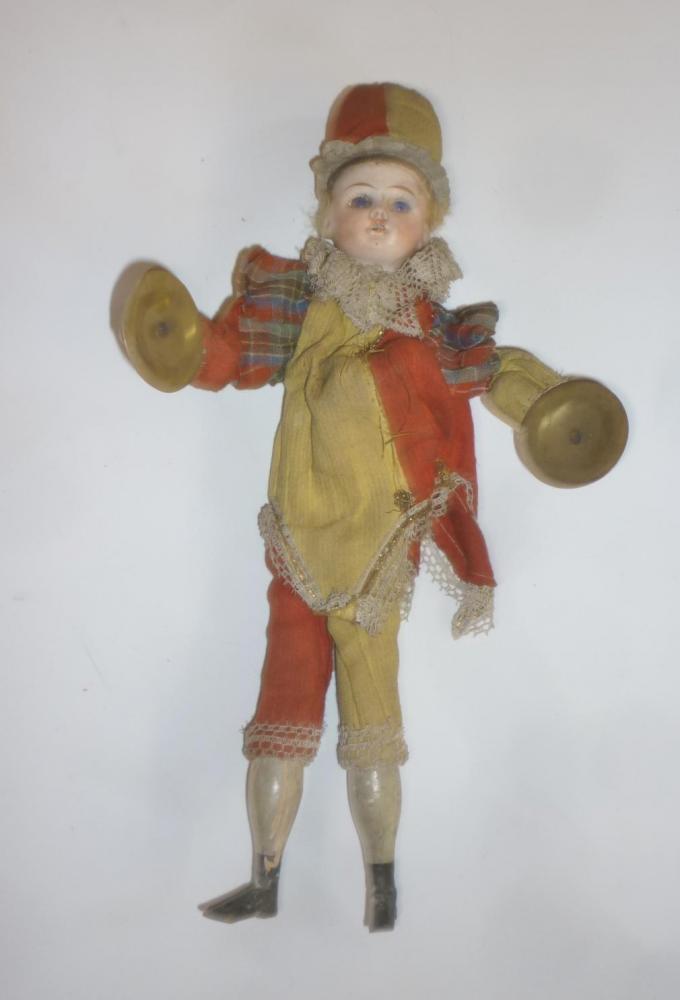A Schoenau & Hoffmeister mechanical doll with bisque head, fixed blue glass eyes, painted wooden