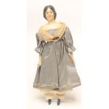 A mid Victorian papier mache doll with moulded hair and painted features, fabric body with painted