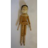 A carved wood "peg" doll, c.1900, with painted head, jointed arms and legs, 12" high