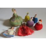 Seven various German bisque pin cushion dolls comprising a character girl with jointed arms, body