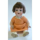 An Ernst Heubach bisque head character doll with blue glass sleeping eyes, open mouth and teeth,