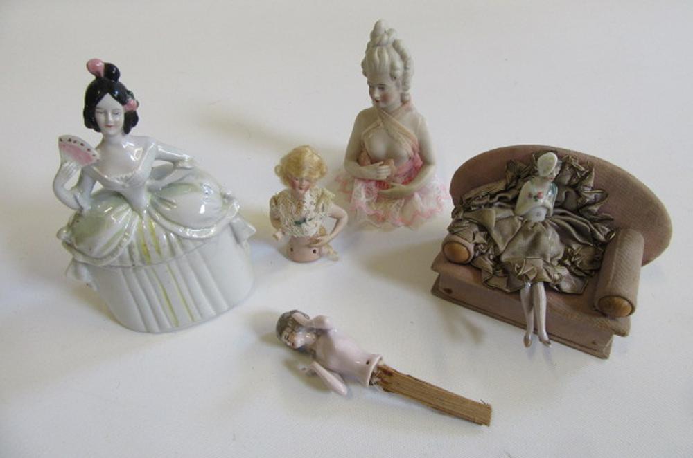 A collection of pin cushion dolls comprising a 1930's lady seated on a settee, 5" long, and three "