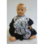 A German all composition baby doll with fixed blue glass eyes, open mouth and teeth, moulded hair,