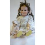 An Armand Marseille bisque head doll with blue glass sleeping eyes, open mouth and teeth, brown