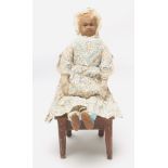 A mid 19th century stocking net doll with painted features and black glass pupils, blonde mohair
