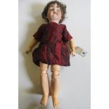 A Kammer & Reinhardt bisque head doll with brown glass sleeping eyes, open mouth and teeth, brown